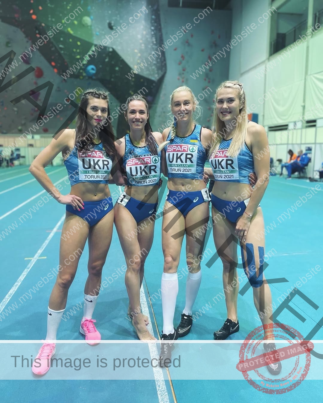 anastasia-bryzgina-ukraine-bryzgina_a-03898 Anastasia Bryzgina, track star from Ukraine 'Four female athletes in blue and white UKR uniforms smile on an indoor track.'.