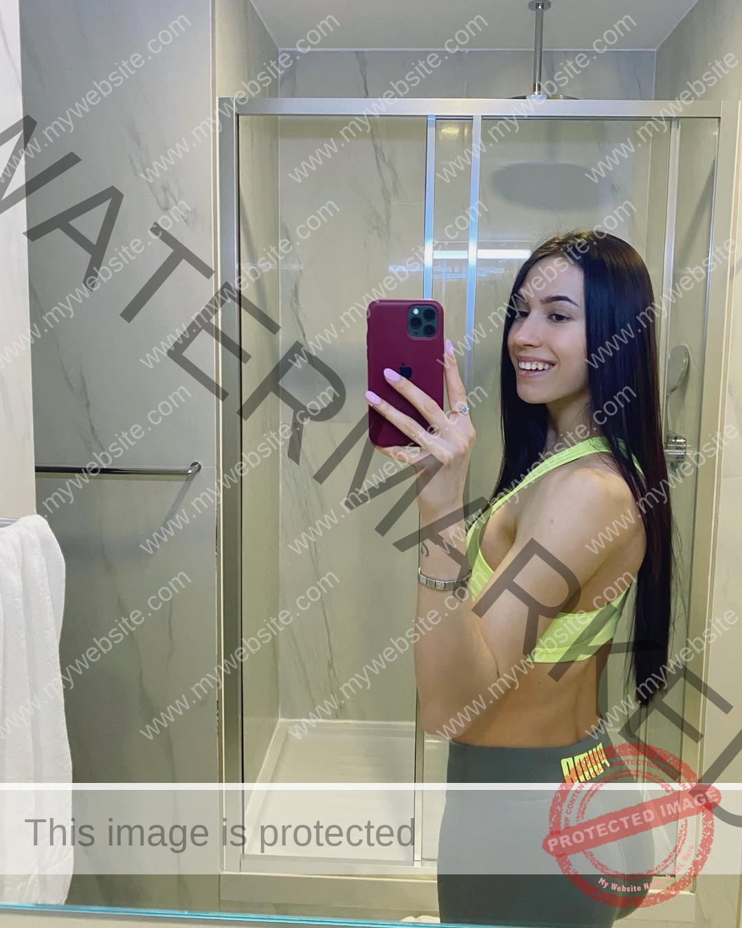 anastasia-bryzgina-ukraine-bryzgina_a-03901 Anastasia Bryzgina, track star from Ukraine, with long dark hair in a yellow sports bra and gray Puma leggings takes a mirror selfie.