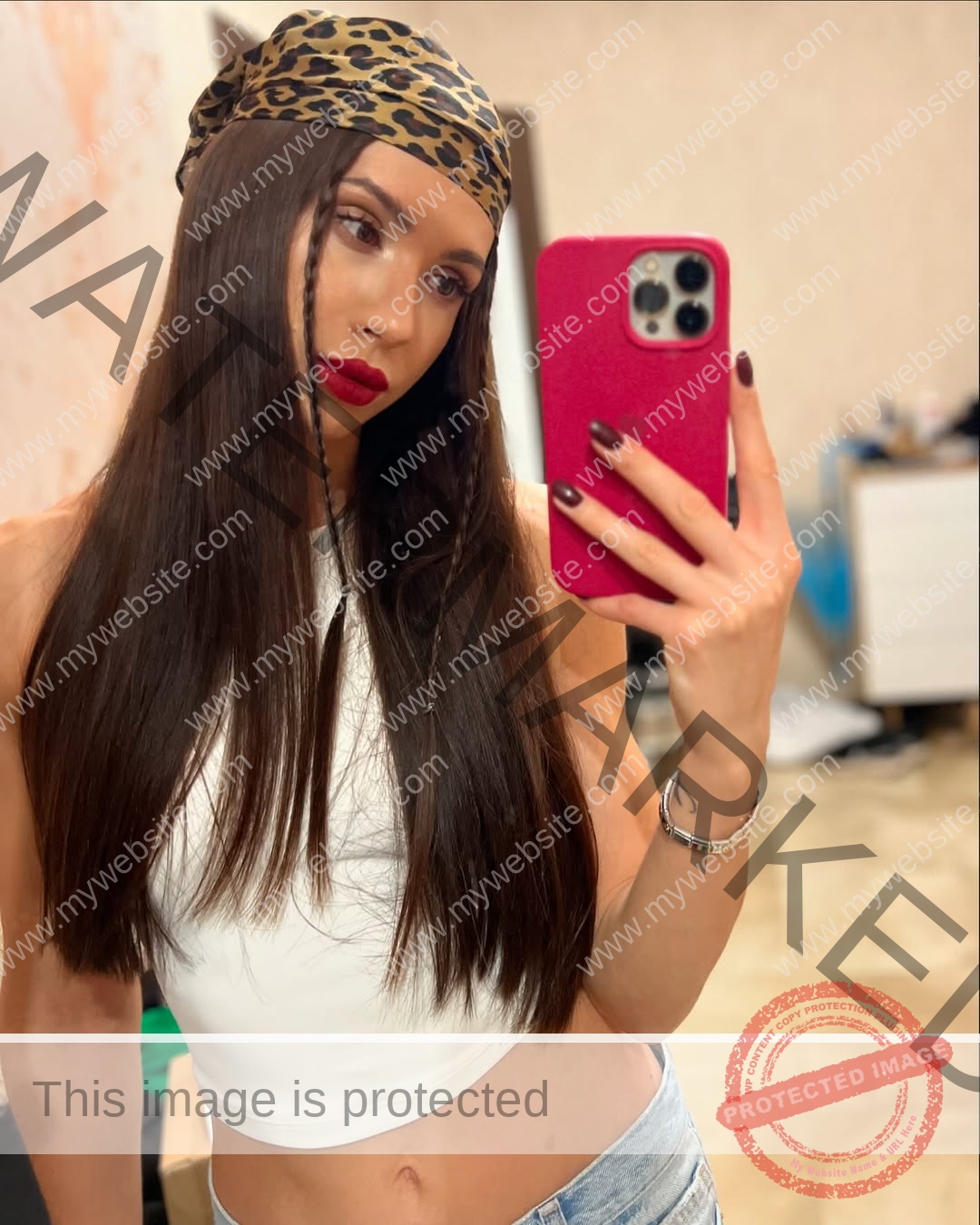 anastasia-bryzgina-ukraine-bryzgina_a-04104 Anastasia Bryzgina, track star from Ukraine, takes a selfie in a leopard headscarf and white top, pink phone in hand.