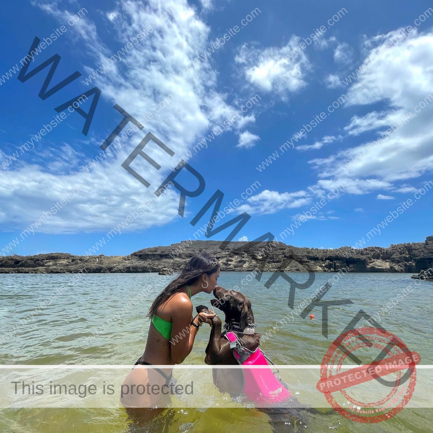 andrea-rivera-aviles-puerto-rico-aandrea.sofiaa-05884 Andrea Rivera Aviles, track athlete from Puerto Rico, kneels in shallow clear water holding paws with a brown dog in a pink life jacket.