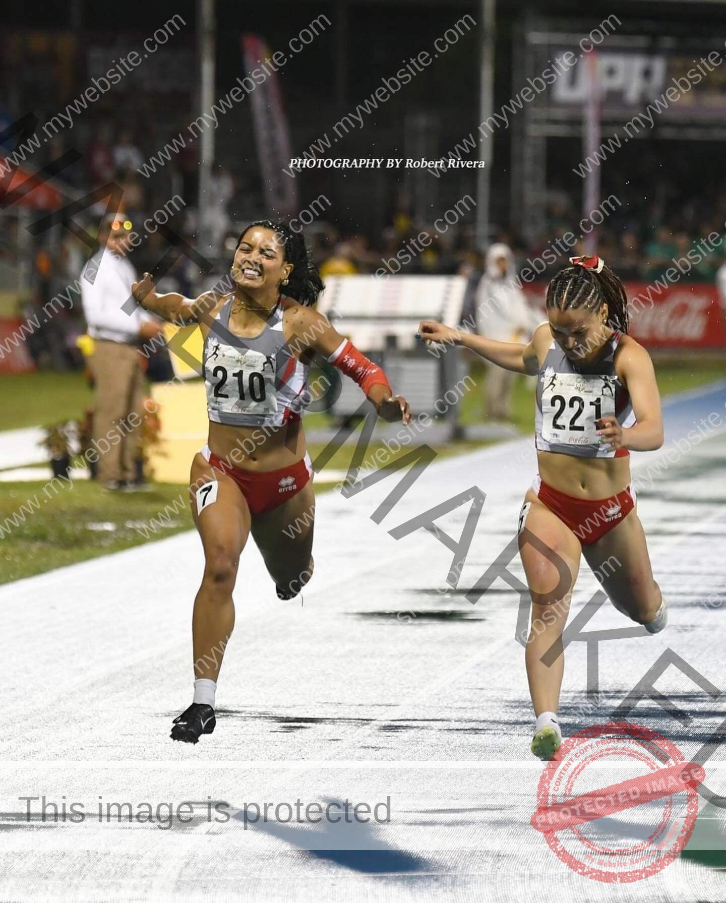 andrea-rivera-aviles-puerto-rico-aandrea.sofiaa-05906 Andrea Rivera Aviles, track athlete from Puerto Rico, races another woman to the finish; both stretch arms, showing joy and intensity.