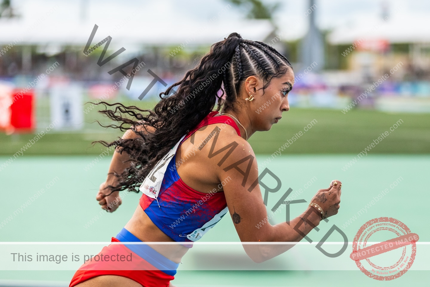 andrea-rivera-aviles-puerto-rico-aandrea.sofiaa-05945 Andrea Rivera Aviles, track athlete from Puerto Rico, sprints on a track in athletic gear, braids trailing and focused amid blurred motion.