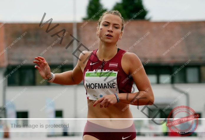 Anna Hofmane Anna Hofmane, a Latvian track and field athlete, wears maroon sportswear and a HOFMANE bib while running outdoors.