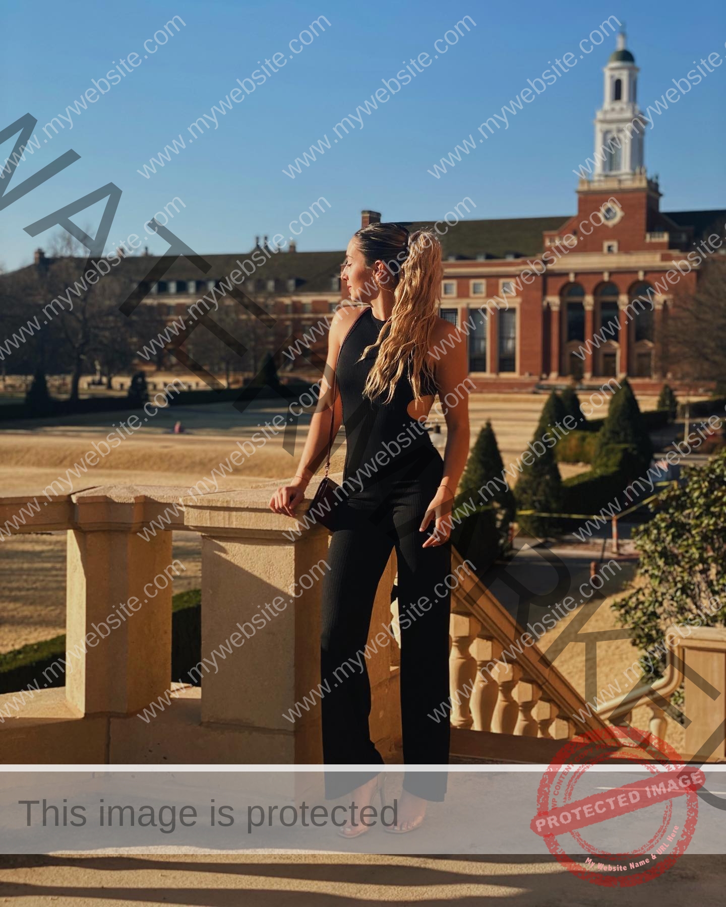 ariadni-adamopoulou-greece-ariadni_adam-09013 Ariadni Adamopoulou, pole vaulter from Greece and Oklahoma State, stands on a sunlit stone balcony in a black jumpsuit, looking sideways.