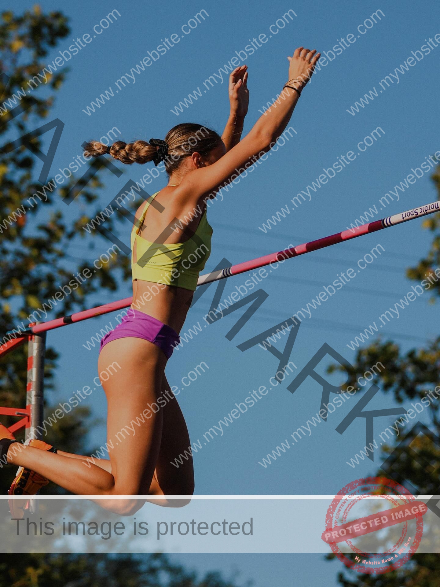 ariadni-adamopoulou-greece-ariadni_adam-09161 Ariadni Adamopoulou, pole vaulter from Greece and Oklahoma State, in a lime green top and purple shorts clears a high jump bar outdoors.