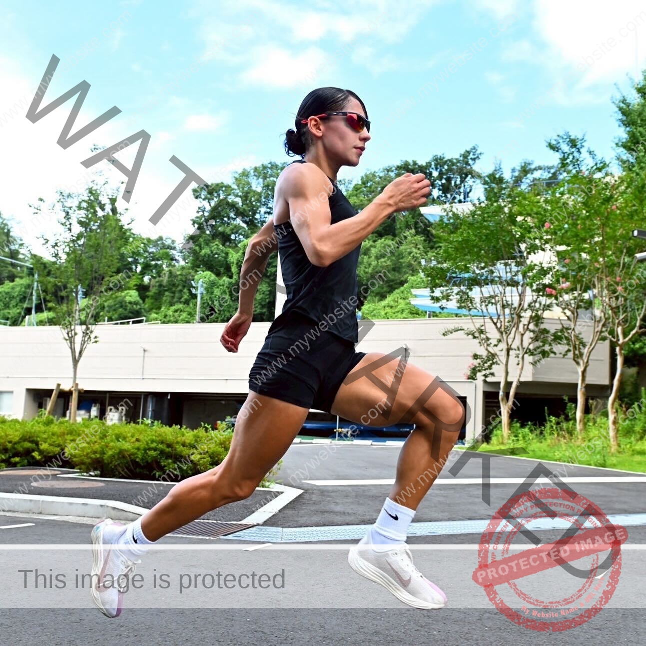 arie-aoki-japan-aokiarie_-x-09186 Arie Aoki, track star from Japan, wearing sunglasses, a black tank top, and shorts is mid-air running outdoors on pavement.