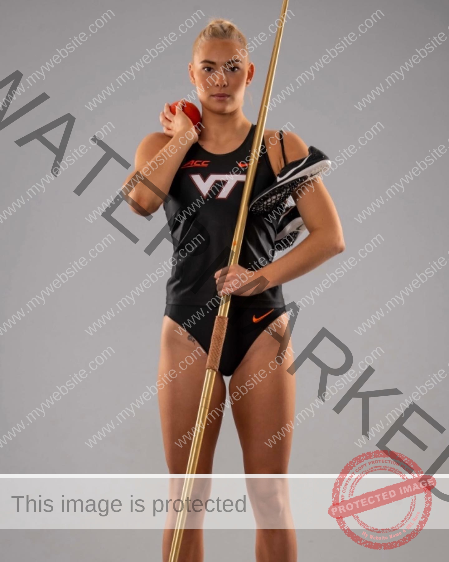 birna-kristjansdottir-iceland-birnakristink-10919 Birna-Kristjansdottir, track athlete from Iceland, in a black Virginia Tech uniform holds a javelin and discus shoe, shot put on shoulder.
