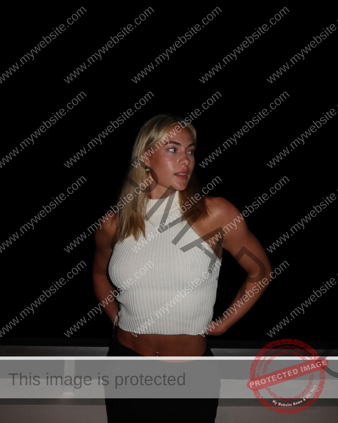 birna-kristjansdottir-iceland-birnakristink-10959 Birna-Kristjansdottir, track athlete from Iceland, stands outside at night in a white sleeveless top and black bottoms, looking left.