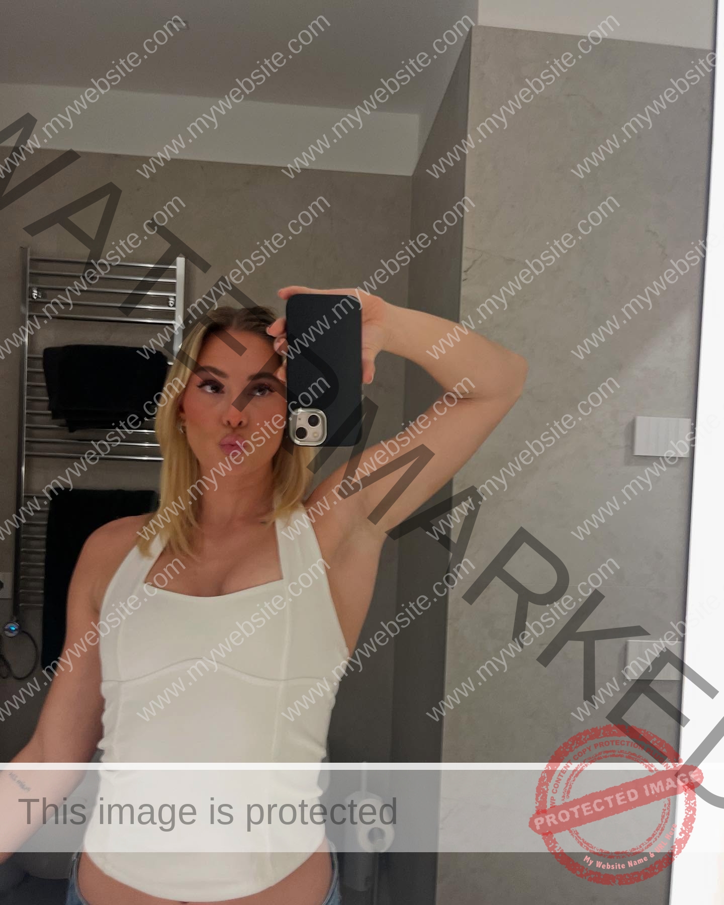 birna-kristjansdottir-iceland-birnakristink-11039 Birna-Kristjansdottir, track athlete from Iceland, with blonde hair in white halter top takes a mirror selfie in a bathroom.