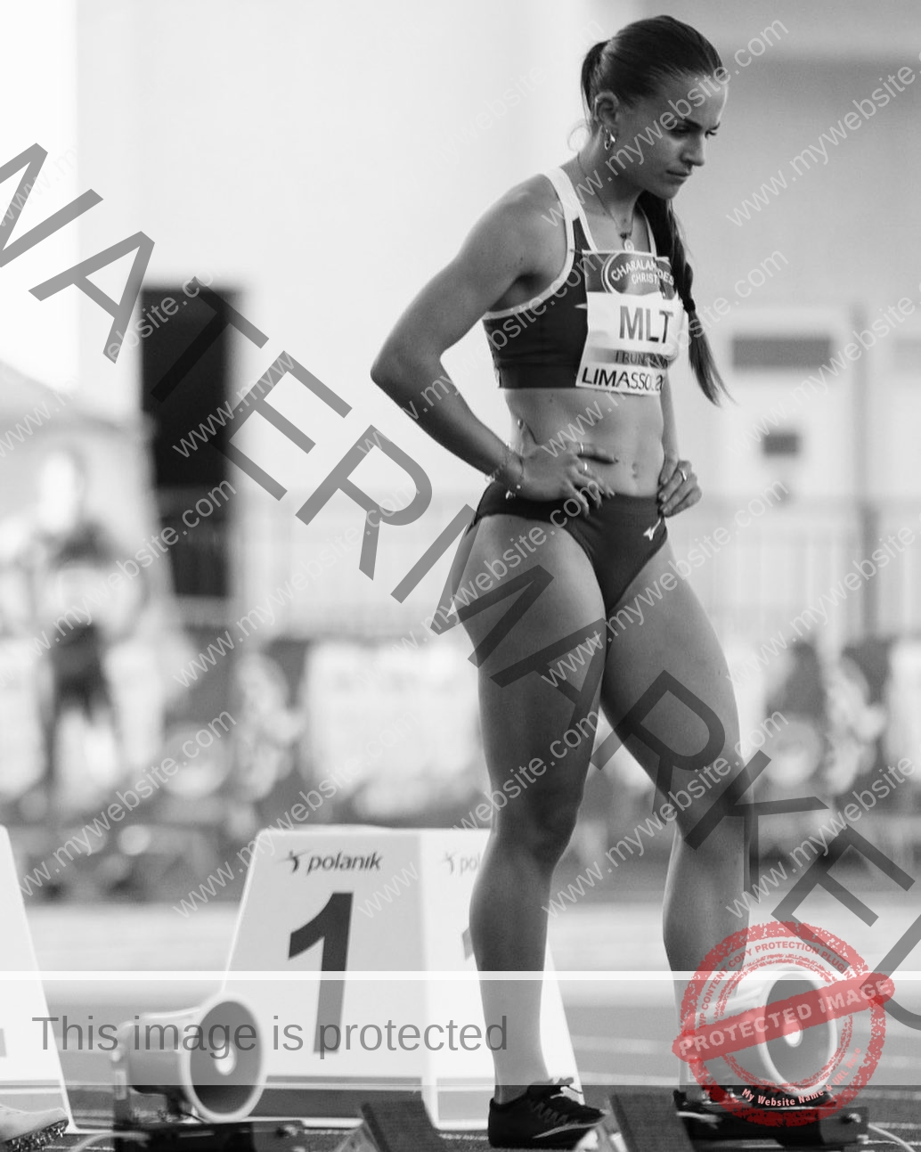 carla-scicluna-malta-carla.scicluna-01651 Carla Scicluna, track athlete from Malta, stands in running gear at the starting blocks, focused and ready before a race. Black and white.