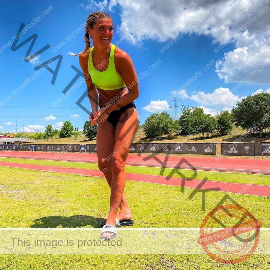 charlotte-wingfield-malta-charlottewingfield.oly-03726 Charlotte Wingfield, track athlete from Malta, smiles in a neon green sports bra and black shorts on a sunny outdoor track field.