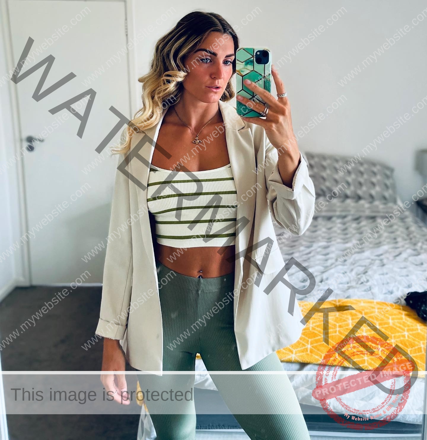 charlotte-wingfield-malta-charlottewingfield.oly-03732 Charlotte Wingfield, track athlete from Malta, takes a mirror selfie in a bedroom, wearing a blazer, crop top, and green leggings.