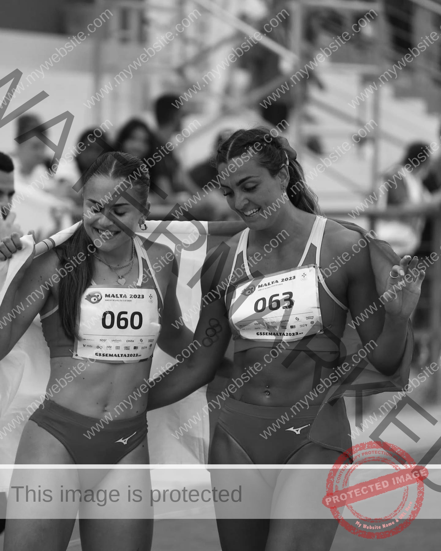 charlotte-wingfield-malta-charlottewingfield.oly-03867 Charlotte Wingfield, track athlete from Malta, stands arm in arm with another athlete, both smiling after a race in black and white.