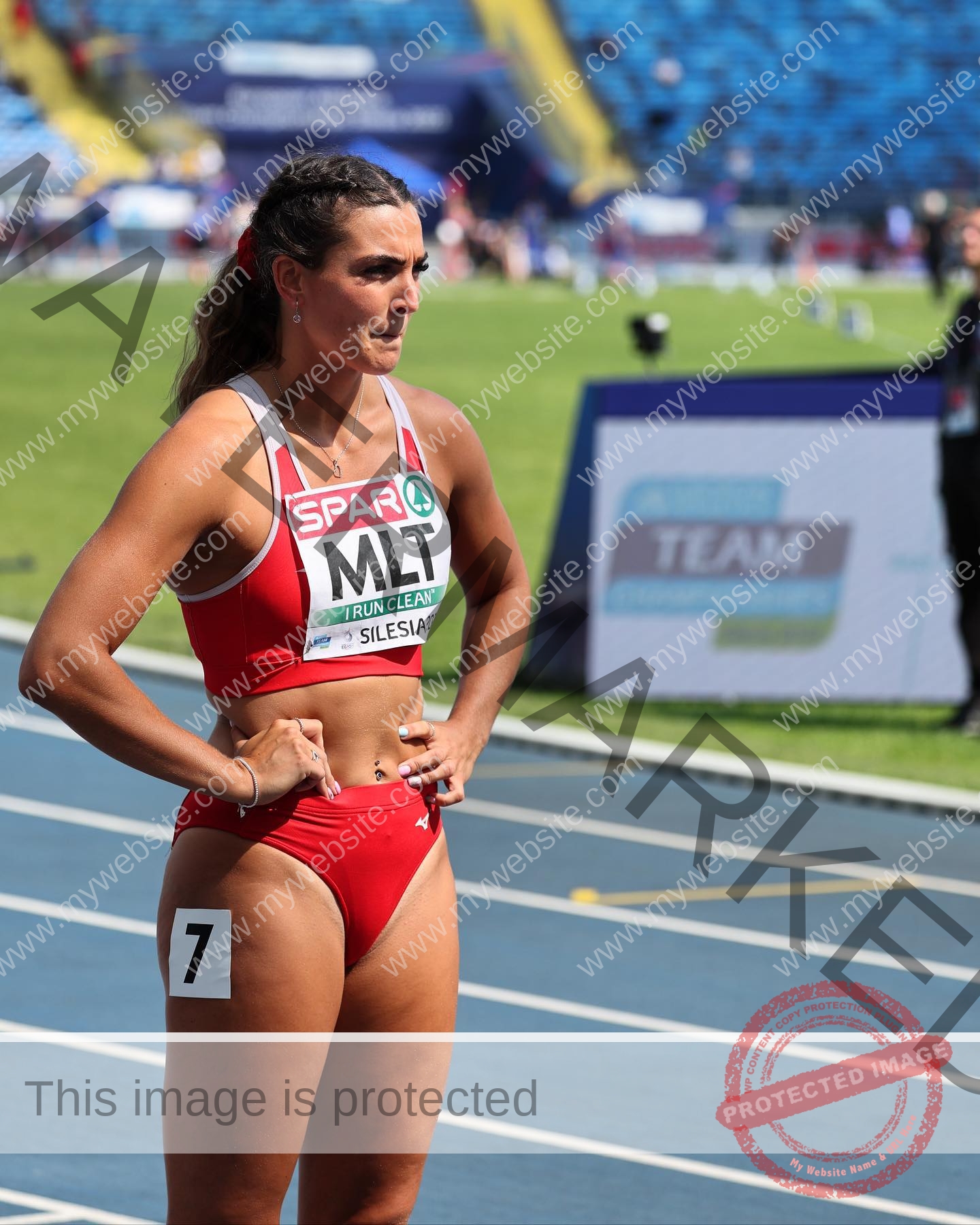 charlotte-wingfield-malta-charlottewingfield.oly-03886 Charlotte Wingfield, track athlete from Malta, in red and white uniform on blue track, wearing bib 7, focused before a race.