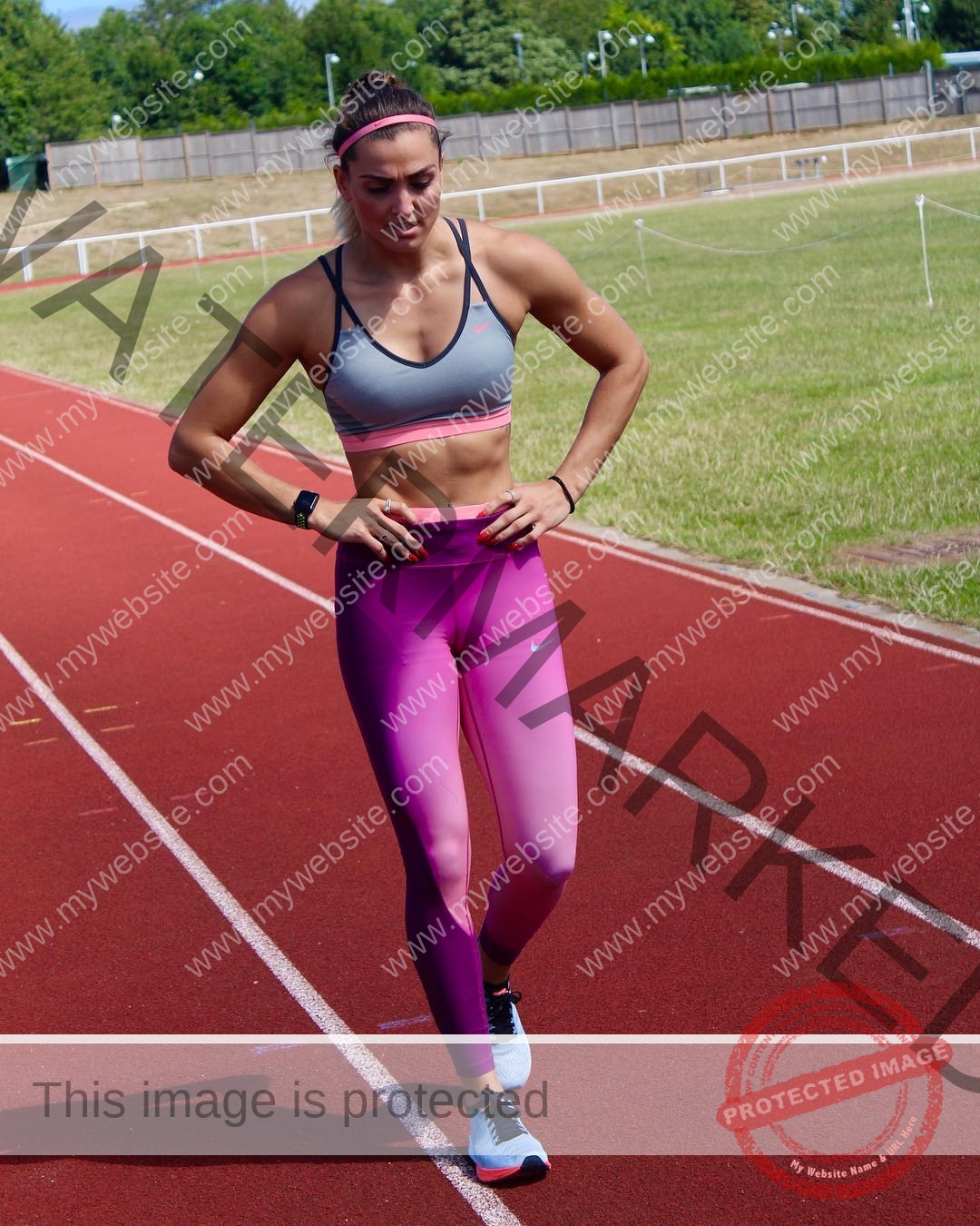 charlotte-wingfield-malta-charlottewingfield.oly-03910 Charlotte Wingfield, track athlete from Malta, in athletic wear walks on a red track in pink leggings and sports bra, trees in background.