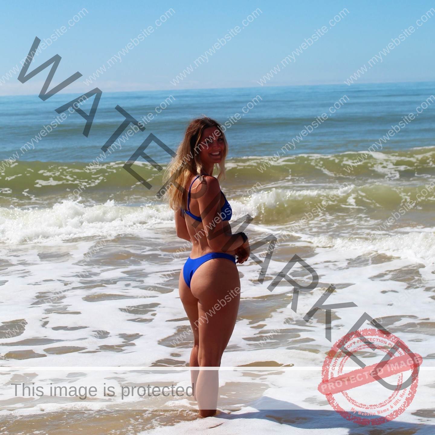 charlotte-wingfield-malta-charlottewingfield.oly-03953 Charlotte Wingfield, track athlete from Malta, stands in a blue bikini on the shoreline, smiling with ocean waves and blue sky behind.