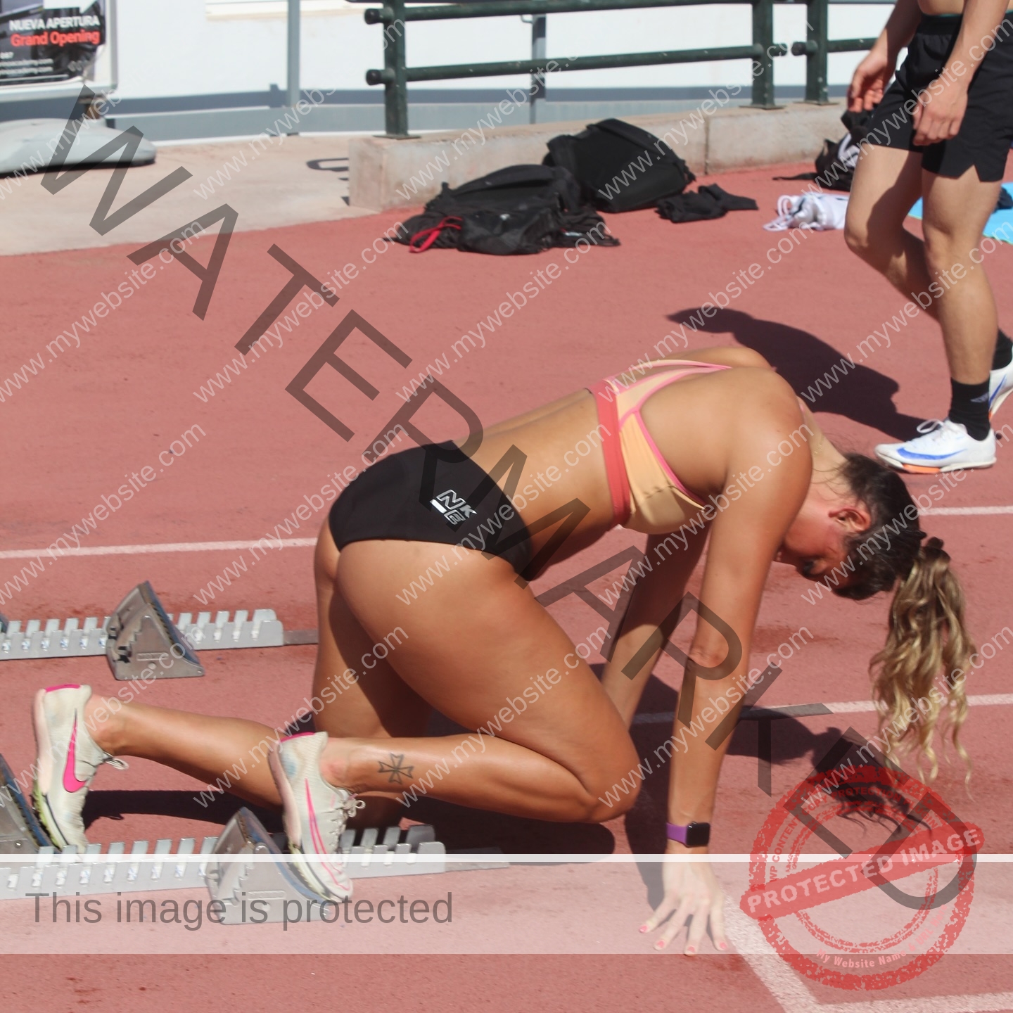charlotte-wingfield-malta-charlottewingfield.oly-03991 Charlotte Wingfield, track athlete from Malta, kneels at the starting blocks on an outdoor track, focused and ready to race.