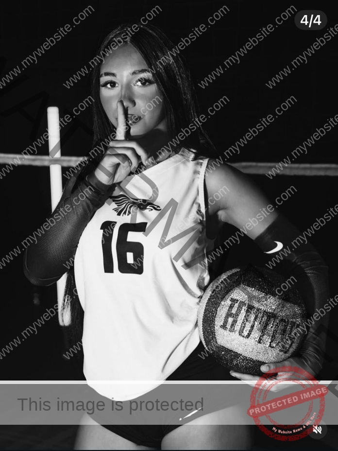 Clara Oliveira Clara Oliveira, a volleyball player from Portugal in jersey 16, holds a Hutch ball and signals silence on a dim court.