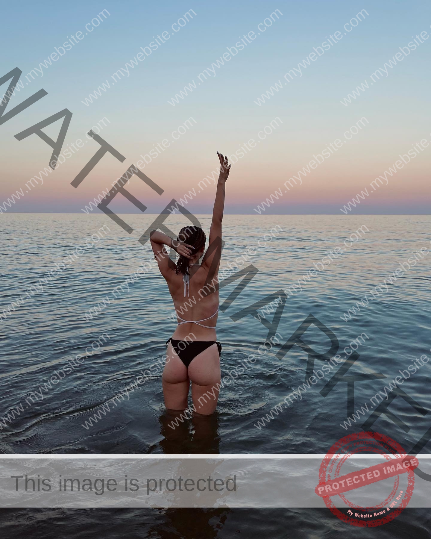daria-polyanskaya-ukraine-polyanska.ya-x-08540 Daria-Polyanskaya, track athlete from Ukraine stands in a bikini in shallow water at sunset, one arm raised, gazing at the ocean.