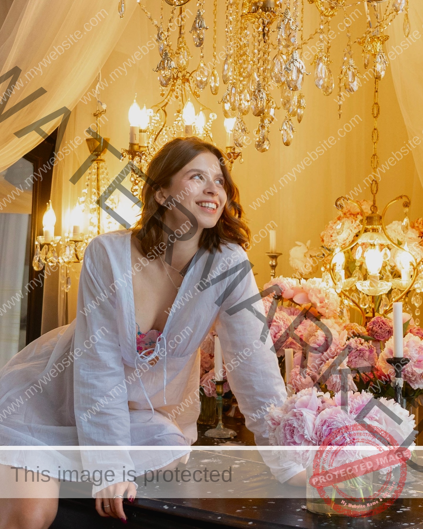 daria-polyanskaya-ukraine-polyanska.ya-x-08699 Daria-Polyanskaya, track athlete from Ukraine, in a white dress sits on a dark table with pink flowers and candles under a gold chandelier.