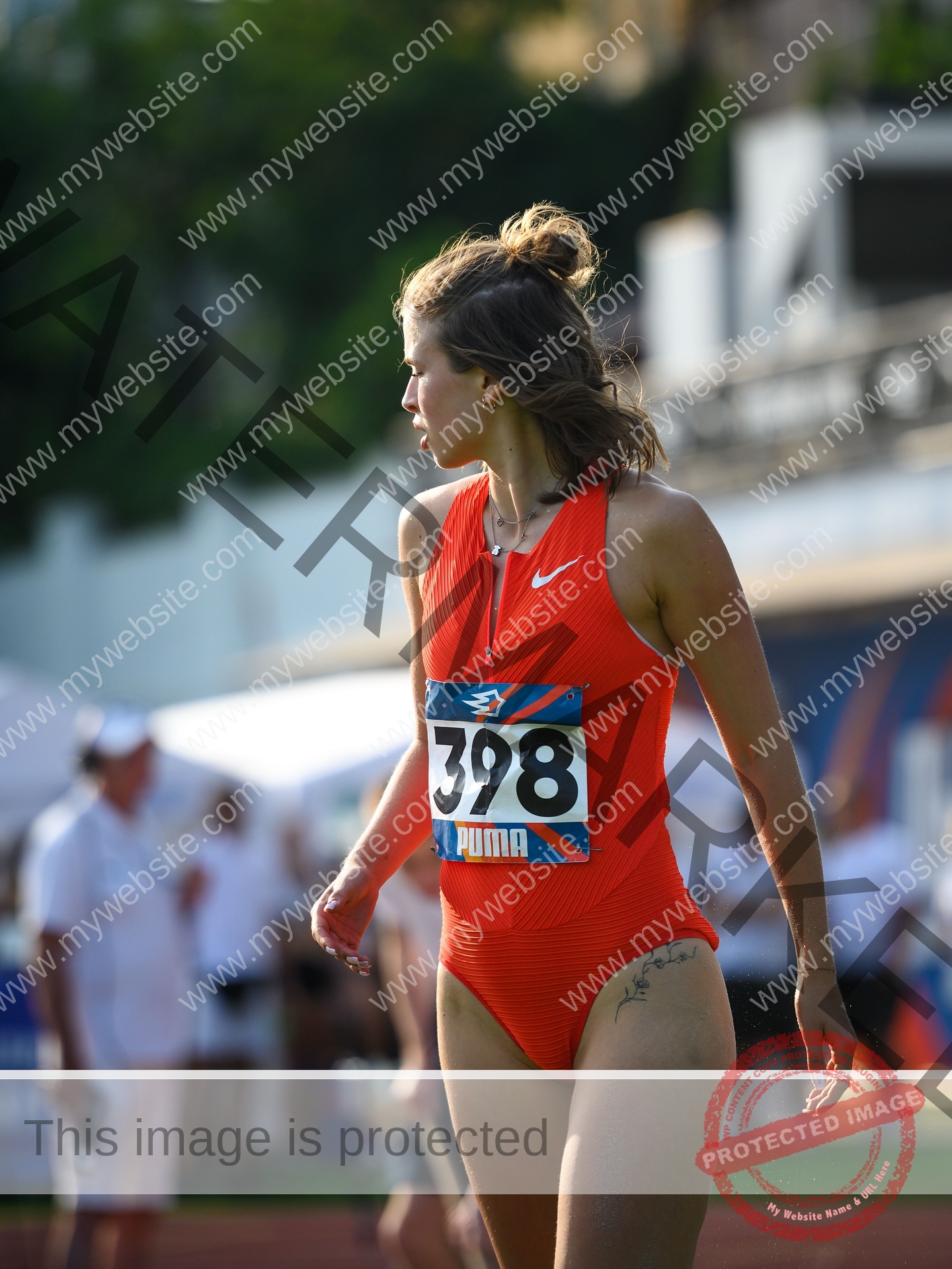 daria-polyanskaya-ukraine-polyanska.ya-x-08736 Daria-Polyanskaya, track athlete from Ukraine in a red athletic suit with number 398 looks to the side at an outdoor track event.