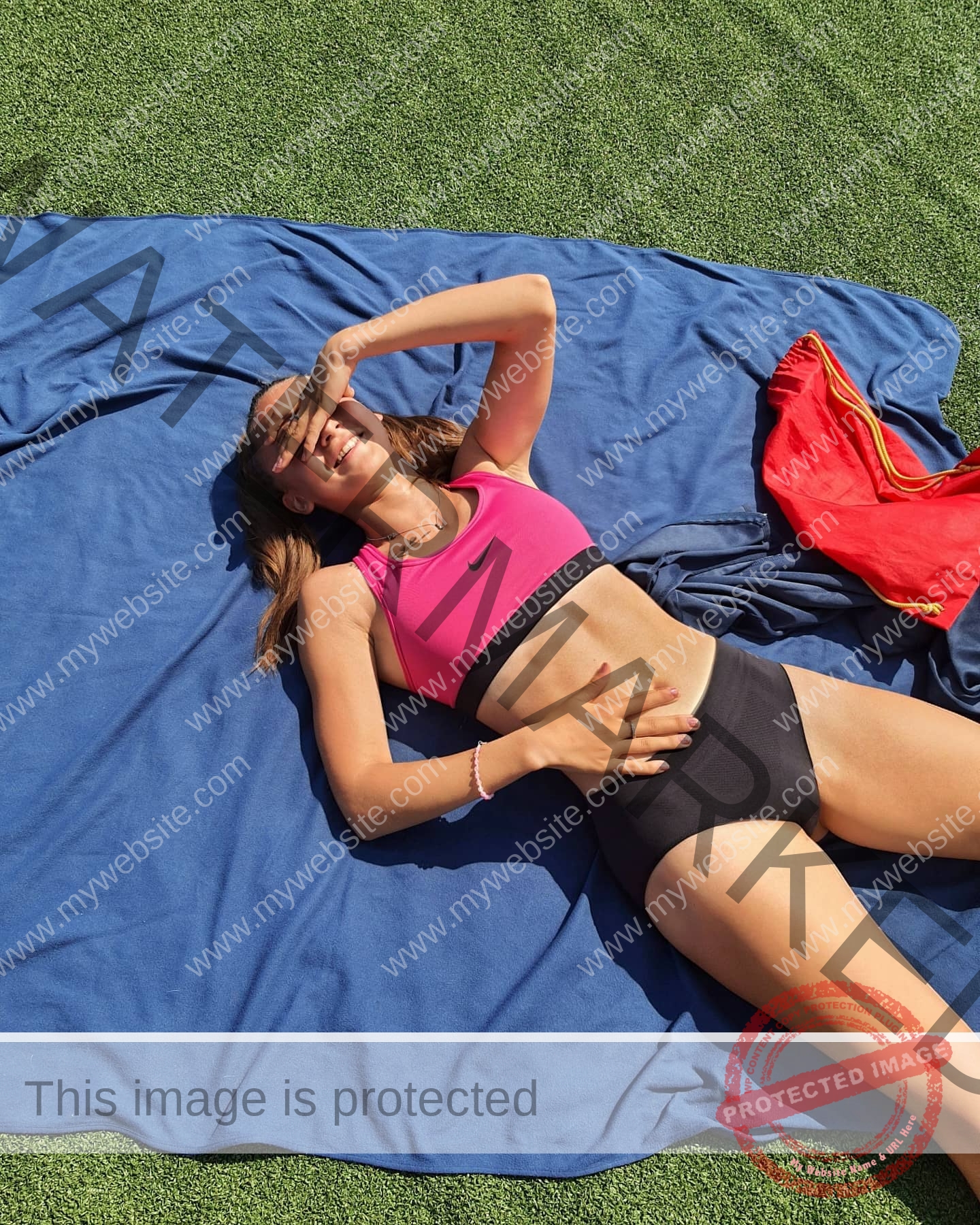 diana-honcharenka-ukraine-goncharenko_43-09516 Diana Honcharenka, track athlete from Ukraine, in athletic wear lies on a blue blanket over grass, smiling with one hand shading her face. A red bag is beside her.