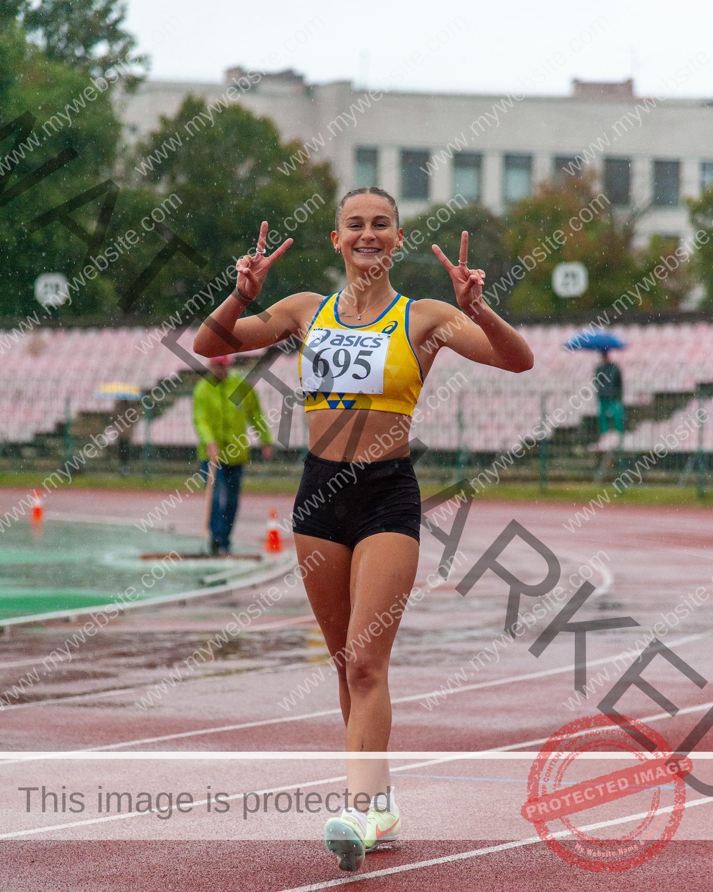 diana-honcharenka-ukraine-goncharenko_43-09657 Diana Honcharenka, track athlete from Ukraine, smiles on a rainy track in a yellow crop top, race bib 695, flashing peace signs.