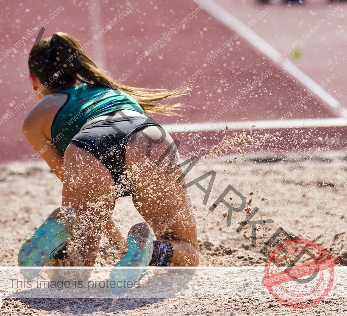 elena-corella-spain-elenacorella_-1051 Elena Corella Spanish track and field athlete Elena Corella lands on her knees and hands in a sandpit, sand spraying as the track shows.