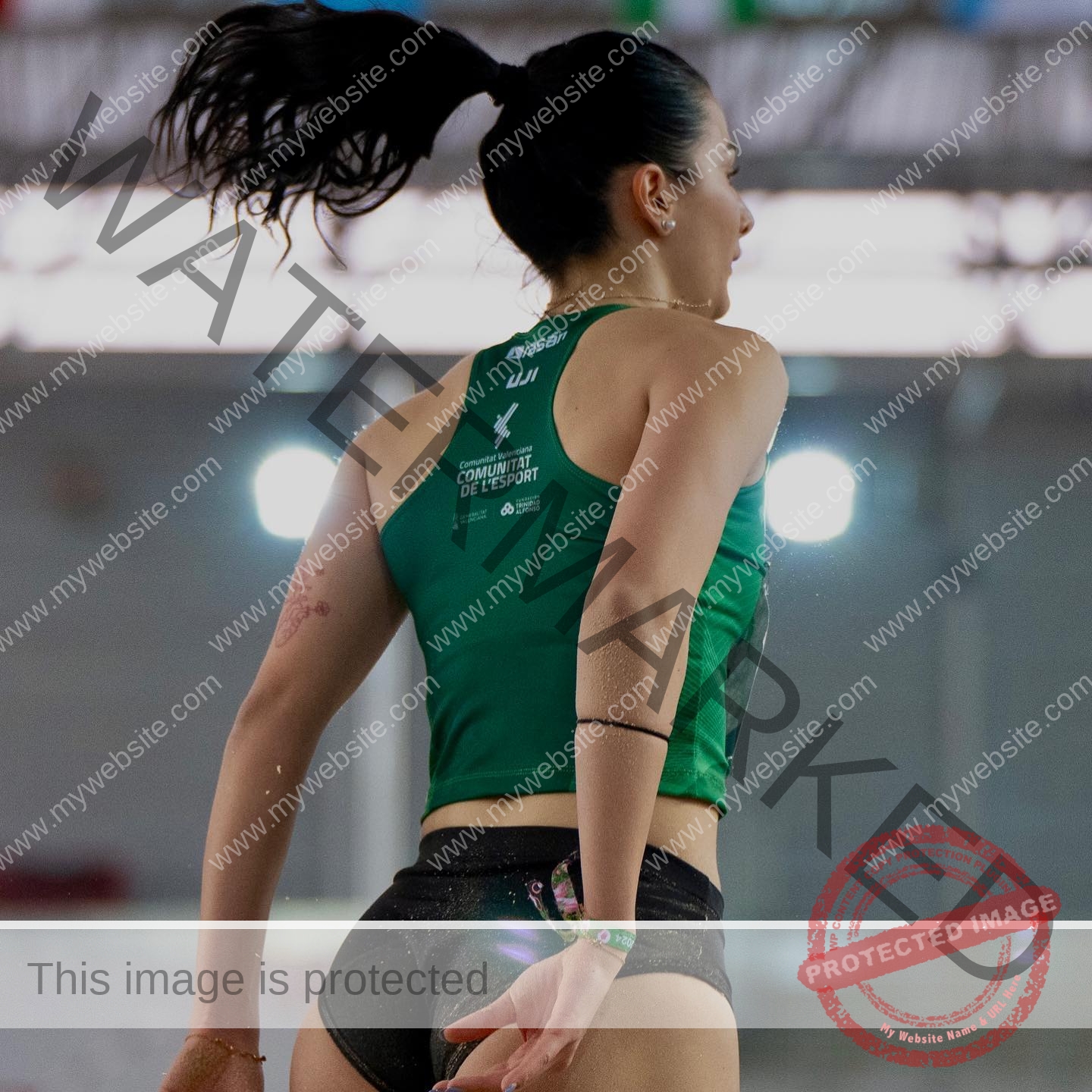 elena-corella-spain-elenacorella_-1057 Elena Corella Track and field athlete Elena Corella from Spain, seen from behind mid-action indoors, wears a green top and black shorts.