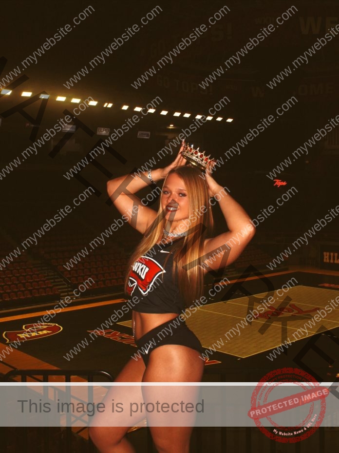 Kennedy Coradini Kennedy Coradini, a young woman in a Western Kentucky track and field outfit, smiles indoors wearing a crown by Tops logos.