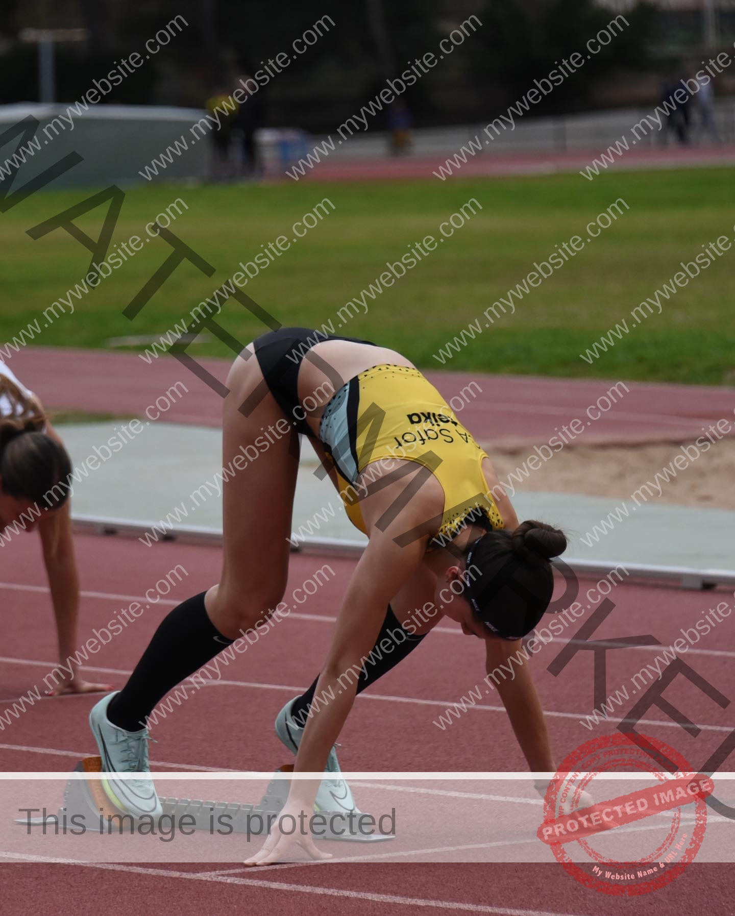 laura-castillo-spain-laura_c.i_-3247 Laura Castillo Laura Castillo, a track and field athlete from Spain, is in starting position on the track, ready to sprint in yellow and black.