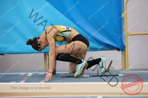 laura-castillo-spain-laura_c.i_-3249 Laura Castillo Spanish track and field athlete Laura Castillo crouches at the starting blocks on an indoor track, ready to race.