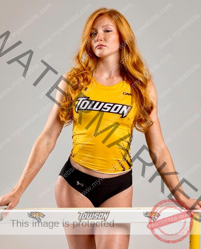 Leeann Redlo Leeann Redlo, in a yellow Towson University tank and black shorts, poses indoors by a Towson Tiger hurdle bar with pride.