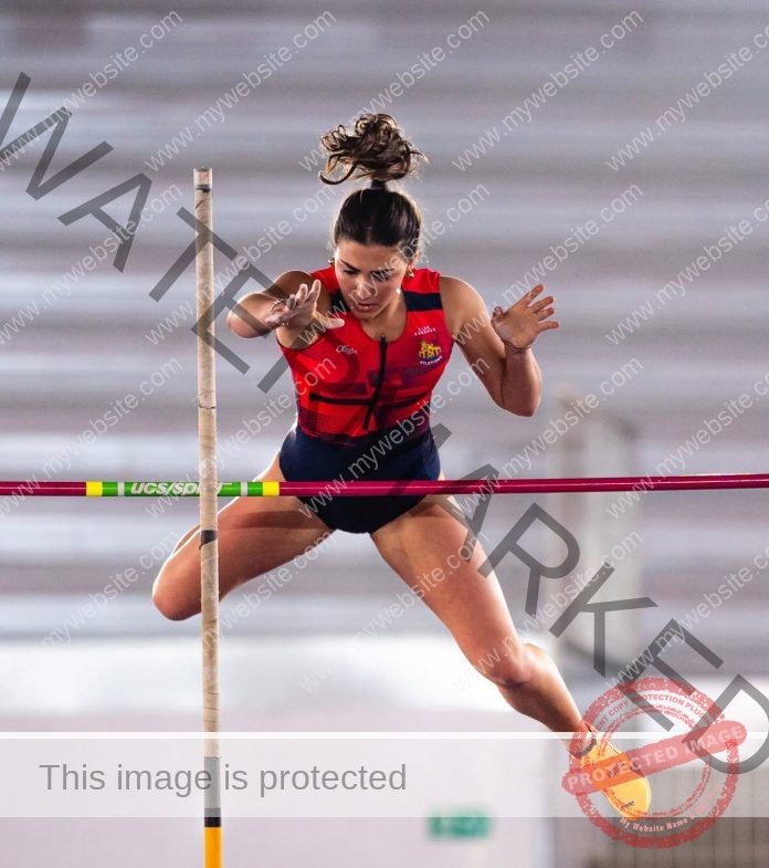 Manuela Blanco Manuela Blanco, a skilled Spanish track and field athlete, leaps over a red bar indoors, arms up, ponytail flying.