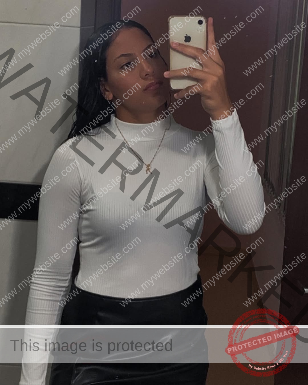 maria-eduarda-dantas-brazil_dudinha_23-1643 Maria Eduarda Dantas, discus thrower from Brazil, wears a white turtleneck and black skirt, taking a mirror selfie with her phone.