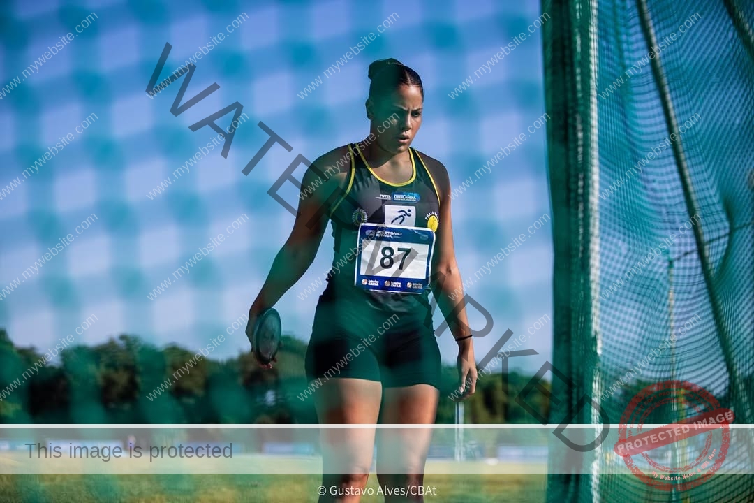maria-eduarda-dantas-brazil_dudinha_23-1653 Maria Eduarda Dantas, discus thrower from Brazil, wears a black uniform and bib 87, ready to throw discus on a sunny field.