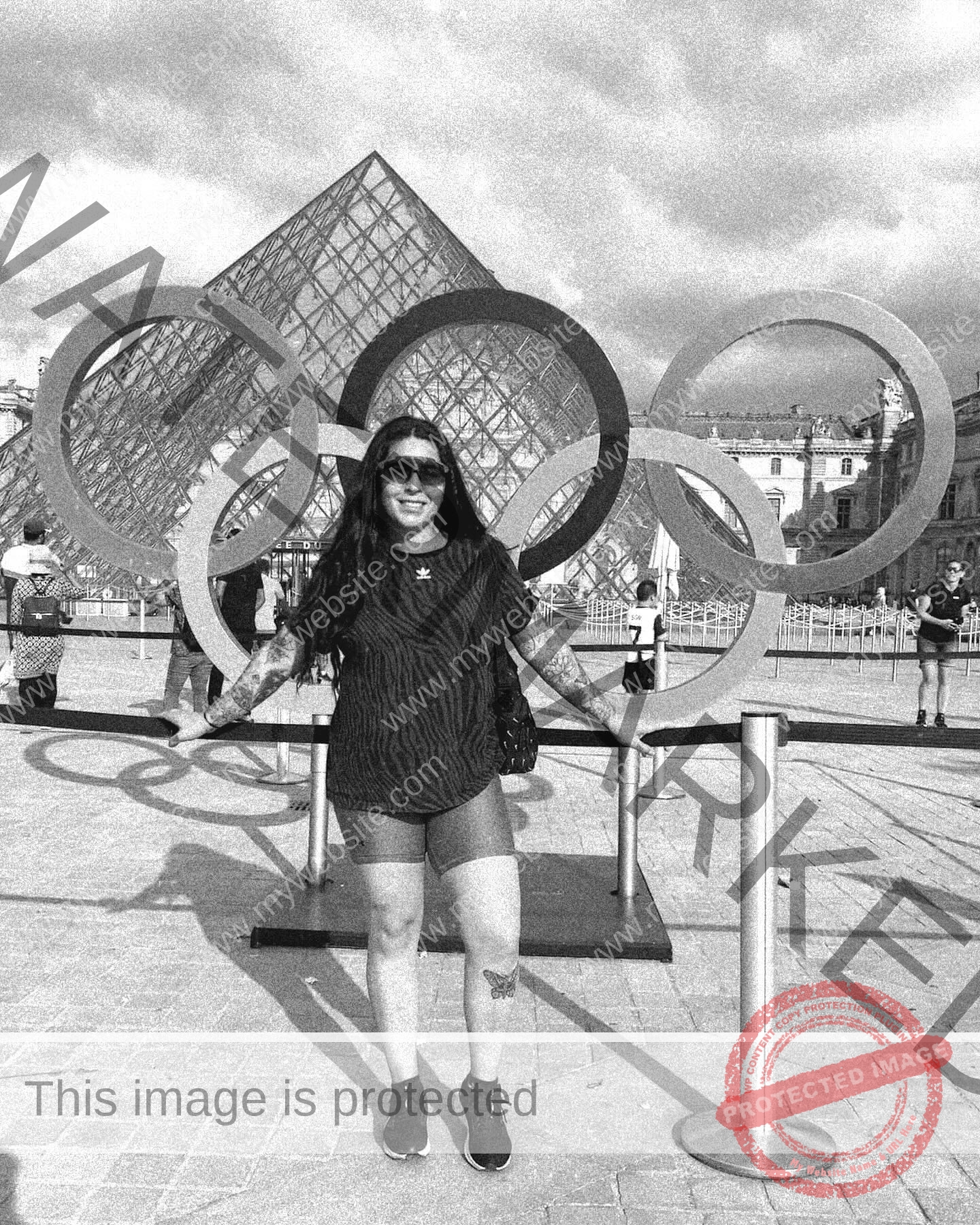 mariana walker-childe-marianawalker_-1864 Mariana Walker, hammer thrower from Chile, poses smiling in front of Olympic rings near the Louvre pyramid on a sunny day.