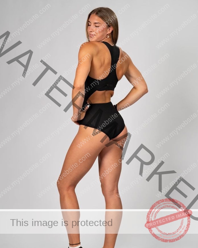 Nicole Krutilova Nicole Krutilova, a track and field athlete from the Czech Republic, poses confidently in a sleeveless black athletic bodysuit, standing sideways with a look over her shoulder against a plain gray background.