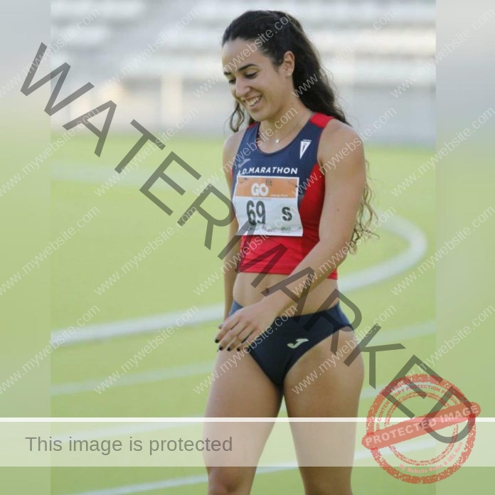 Paula Soria A female track and field athlete from Spain, in red and navy uniform number 69, smiles on a track; stadium seats blurred.