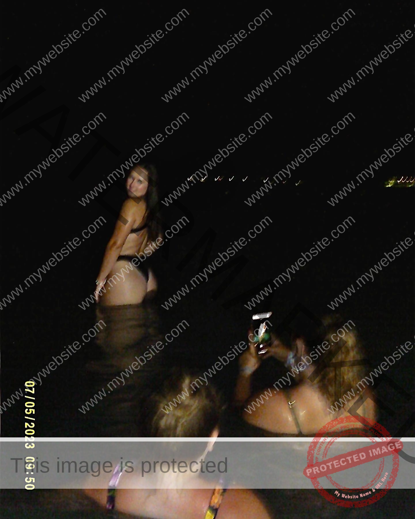 rosa-gergely-wake-forest-th-ro_gerg-08278 Rosa Gergely wades in dark water with two women at night; one smiles for a photo after a Wake Forest track event. Soft lights glow.