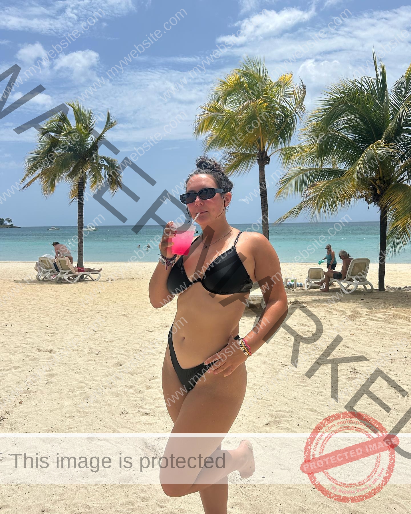 rosa-gergely-wake-forest-th-ro_gerg-1965 Rosa Gergely, javelin thrower from Wake Forest, stands on a sandy beach in a black bikini, holding a pink drink by the ocean.