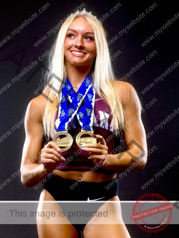 Tara Ohlwiler, a smiling female athlete with long blonde hair, holds two gold medals in maroon top and black Nike shorts.