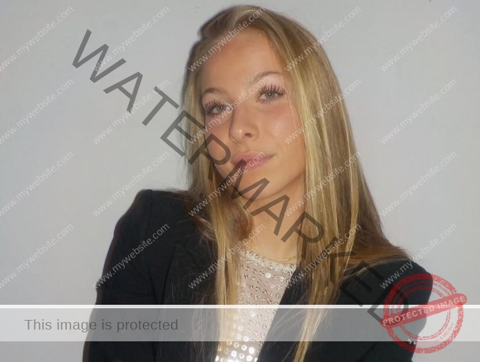 Amaya Kruse Jorgensen, track and field star from Denmark, with long blonde hair in a black blazer and sparkly top, poses neutrally.