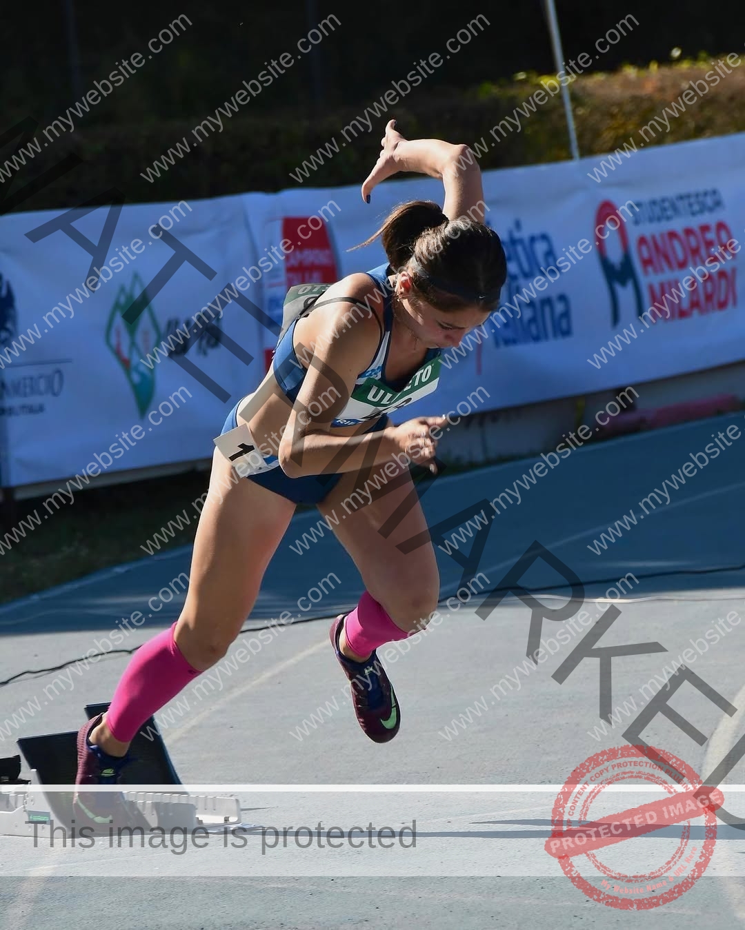 anabel-vitale-italy-anabelvitale-0441 Anabel Vitale, track and field star from Italy, sprints off starting blocks in sportswear and pink socks, focused on the race.