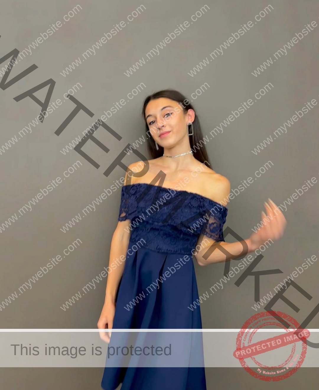 anabel-vitale-italy-anabelvitale-0513 Anabel Vitale, track and field star from Italy, in a navy off-shoulder dress poses against a gray background, smiling slightly.