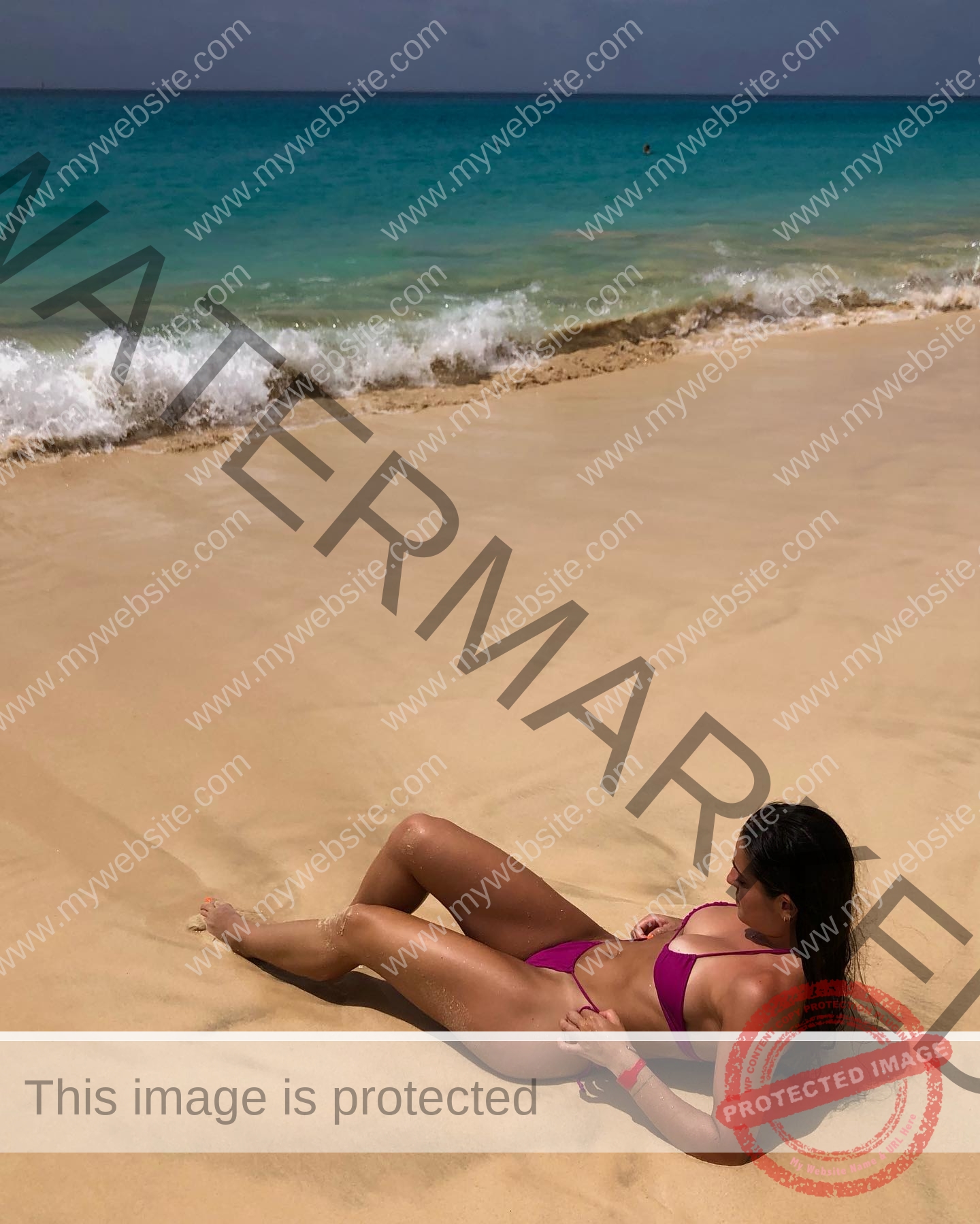 claudia-camacho-spain-clauudiacamacho-1400 Claudia Camacho, track and field star from Spain, relaxes on golden sand in a pink bikini as gentle waves roll under a bright sky.