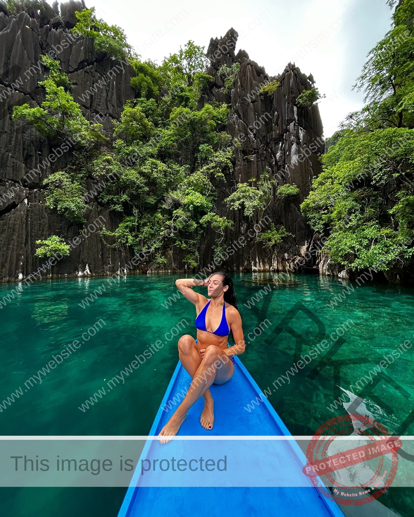 claudia-camacho-spain-clauudiacamacho-1455 Claudia Camacho, track and field star from Spain, in a blue bikini relaxes on a boat amid turquoise water and lush green cliffs.