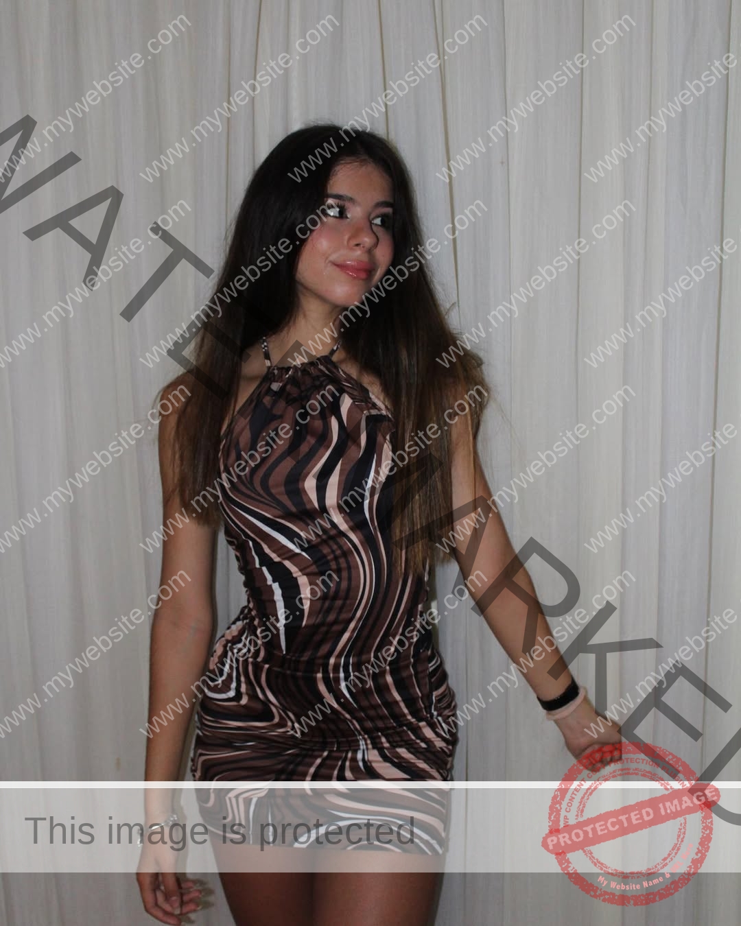 emma-deana-spain-emmadeana-15408 Emma Deana, track and field star from Spain, with long dark hair, stands before white curtains in a swirled sleeveless dress, smiling.