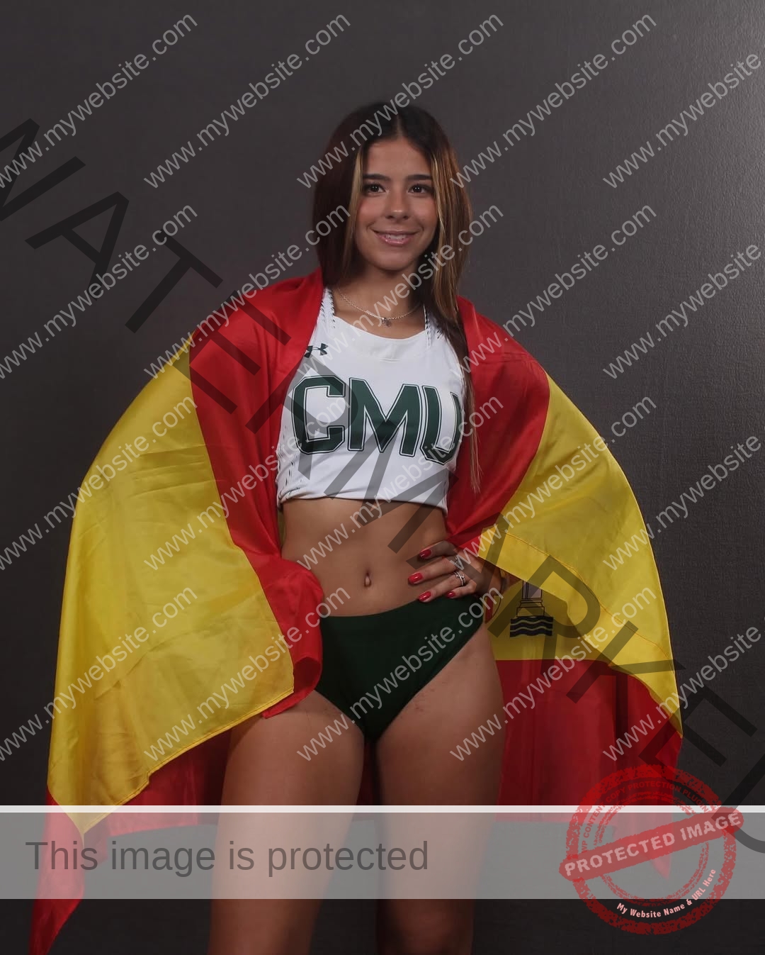 emma-deana-spain-emmadeana-15445 Emma Deana, track and field star from Spain, smiles in a CMU uniform with a red and yellow flag on her shoulders, dark background.