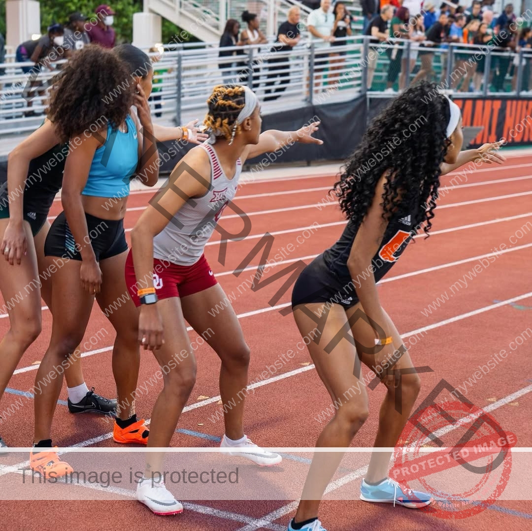 kristina-knott-philippines-knottyourcheese-x-18830 Kristina Knott, track and field star from Philippines stands with three female athletes at a relay start line, ready to race; crowd behind.
